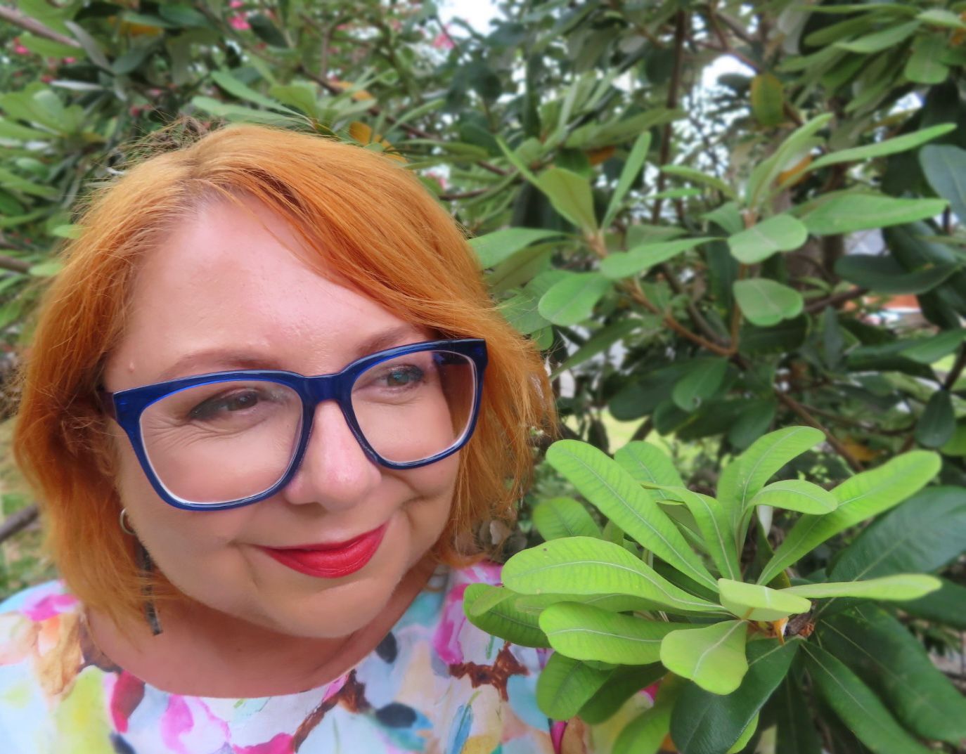 Dr Holly Parsons looking at a plant while smiling